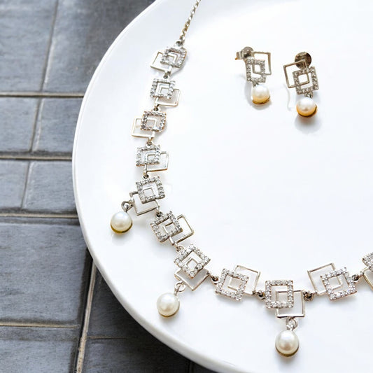 Jewelry set with necklace and earrings on a white plate