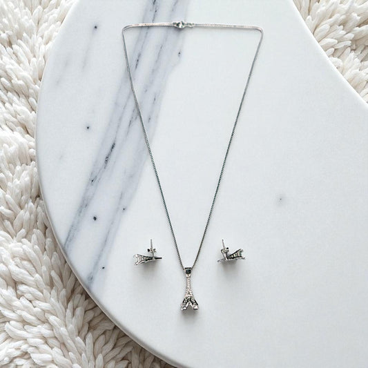 Silver necklace with matching earrings on a marble surface