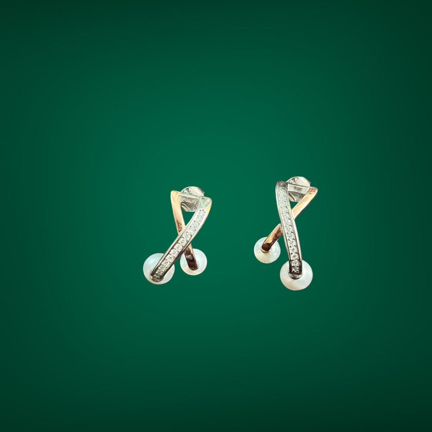 Pair of gold earrings with a green background
