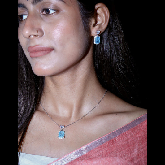 Woman wearing a necklace and earrings with a dark background