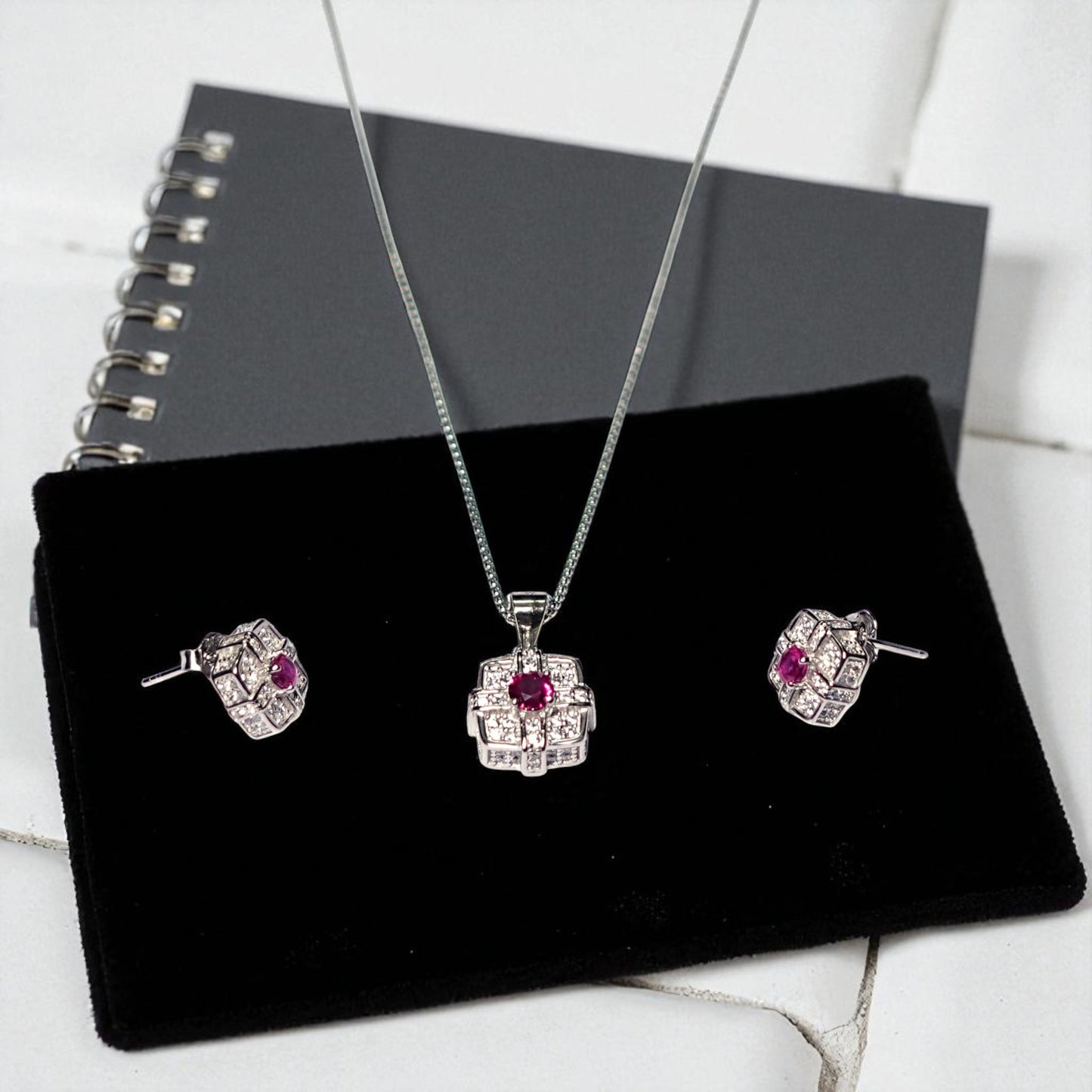 Jewelry set with pendant and earrings on a black display stand