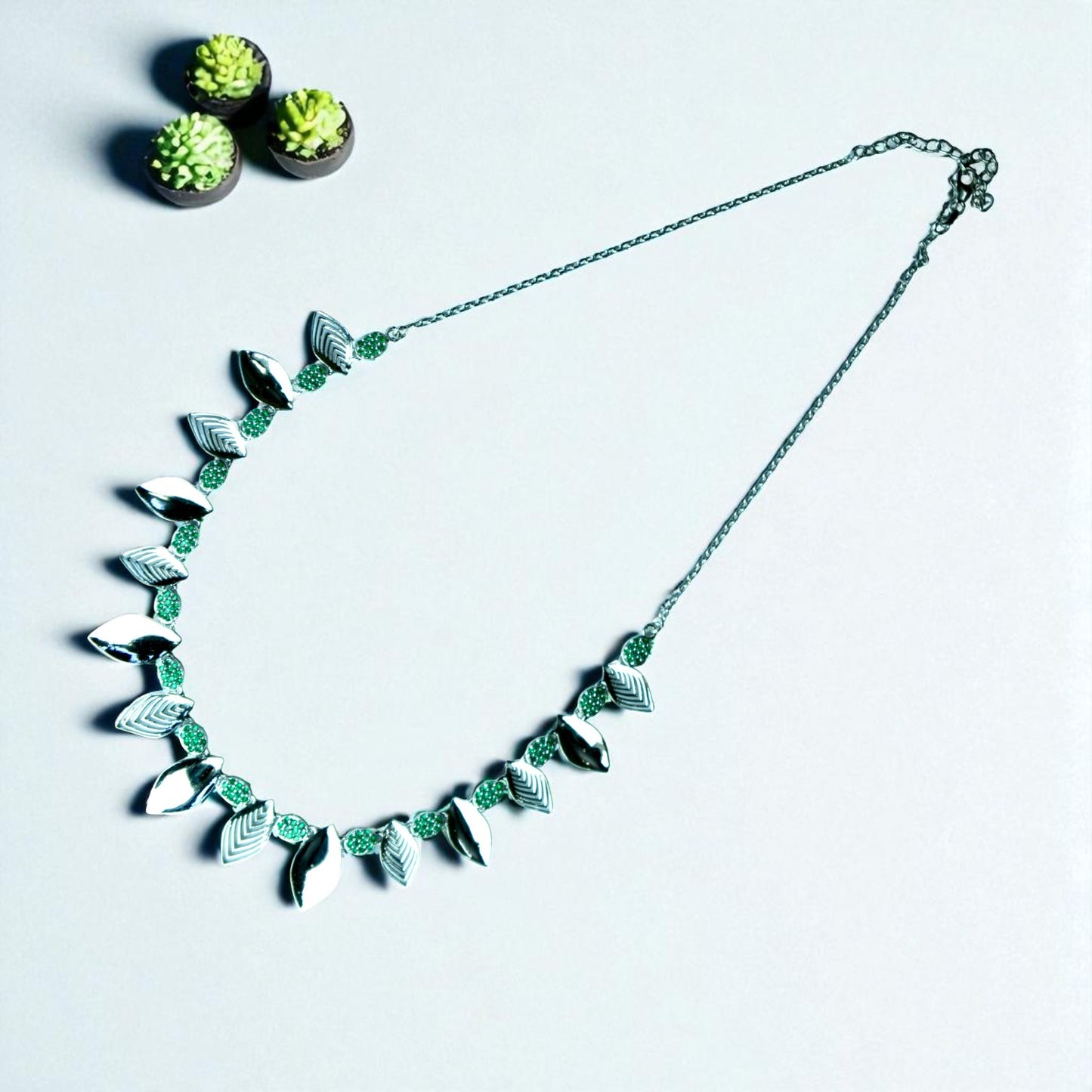 Necklace with leaf-like designs on a light gray background