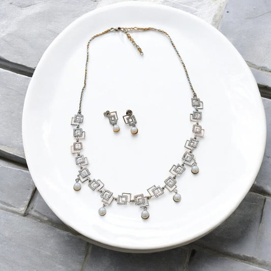 Jewelry set with necklace and earrings on a white plate