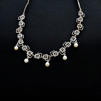 Silver necklace with geometric design and pearl-like beads on a black background
