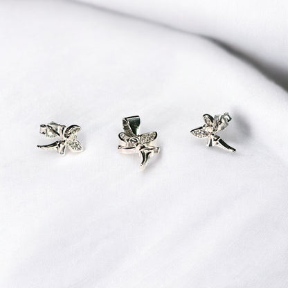 Three silver fairy-shaped earrings on a white surface