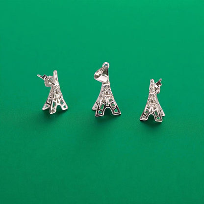 Three silver Eiffel Tower charms on a green background