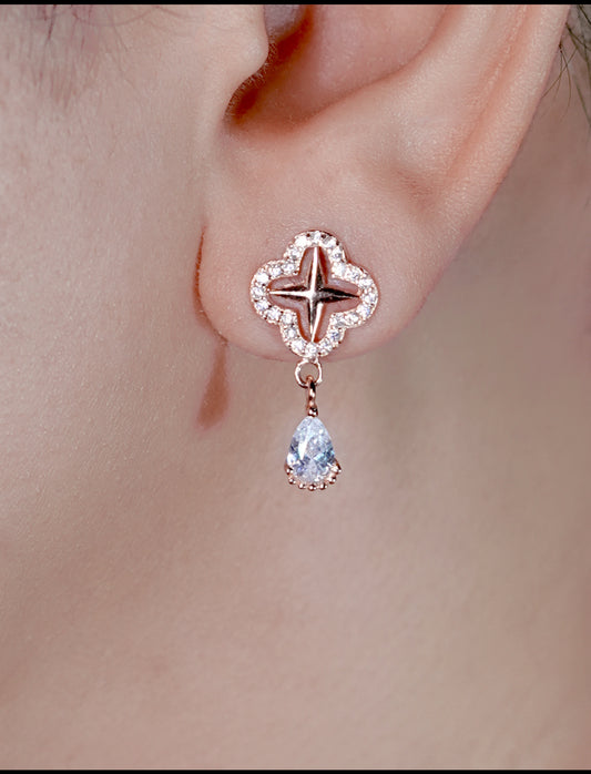 Close-up of a diamond earring worn on an ear with a soft background