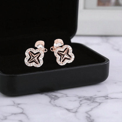 Star-shaped earrings in a black jewelry box on a marble surface