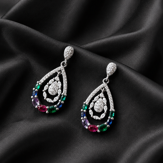 Teardrop-shaped earrings with colorful gemstones on a black satin background