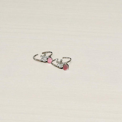 Pair of earrings with pink accents on a light beige background