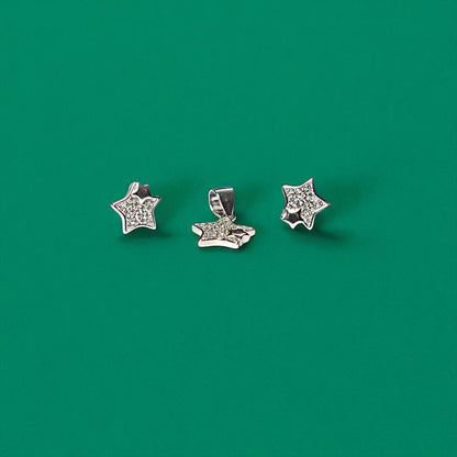 Three star-shaped silver earrings on a green background