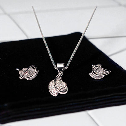 Silver jewelry set with necklace and earrings on a black surface