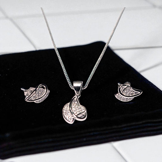 Silver jewelry set with necklace and earrings on a black surface