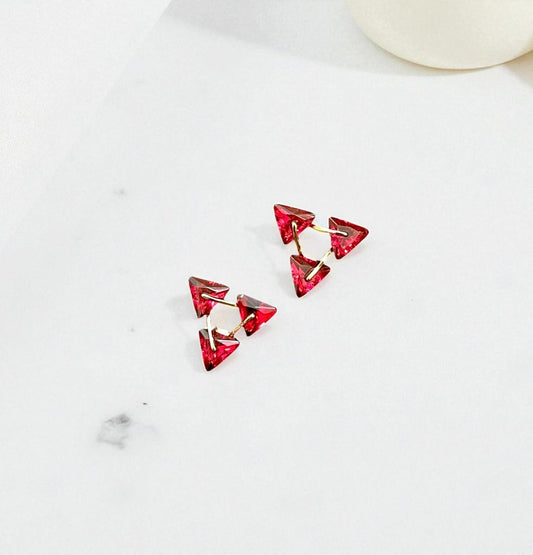 Red triangular earrings on a white background
