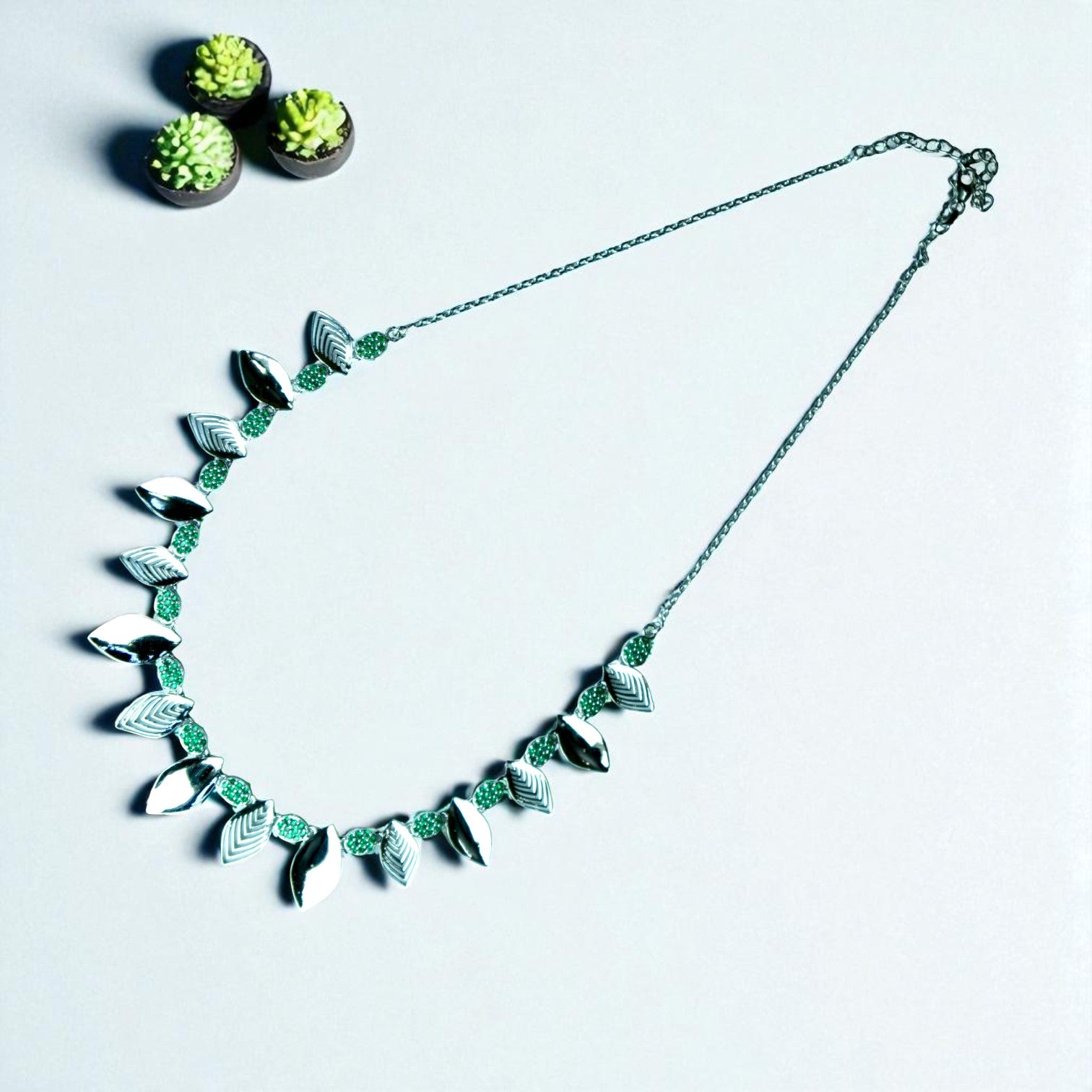 Necklace with leaf-like designs on a light gray background