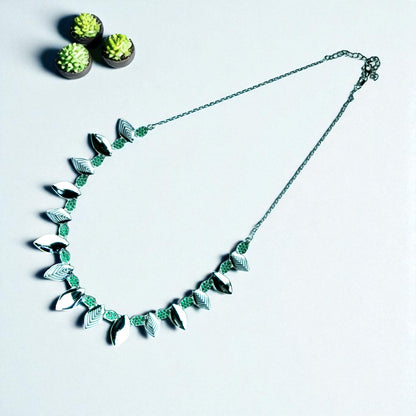 Necklace with leaf-like designs on a light gray background
